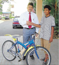 Perlis MB presenting a bicycle to a young traffic offender.